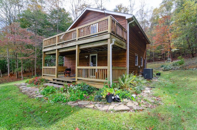 exterior space with central air condition unit, a wooden deck, and a front lawn