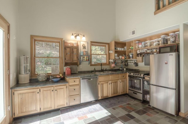 kitchen featuring visible vents, open shelves, a high ceiling, a sink, and appliances with stainless steel finishes