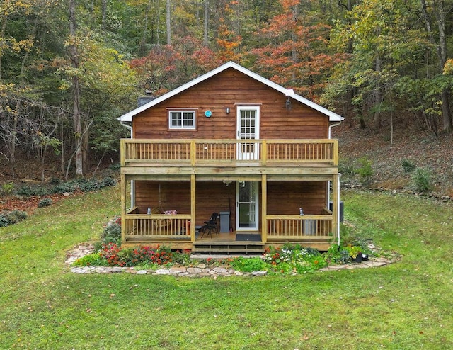 view of front of home featuring a forest view and a front lawn