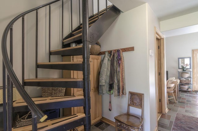 staircase featuring stone finish floor