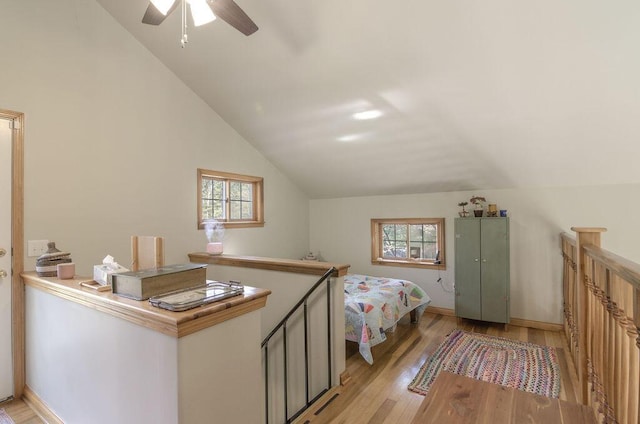 bedroom with multiple windows, light wood-type flooring, and lofted ceiling