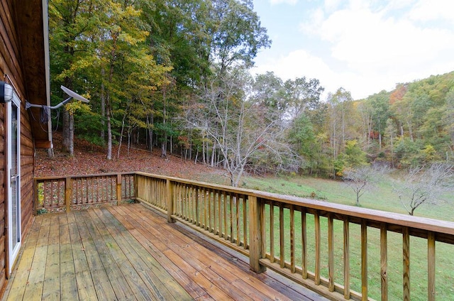 deck featuring a forest view and a yard