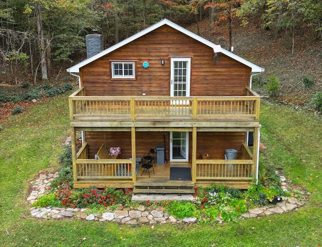 back of house with a wooden deck and a chimney