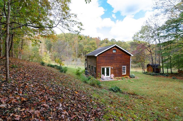 view of property exterior with a view of trees and a yard