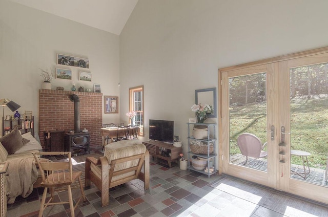 living area featuring high vaulted ceiling and a wood stove