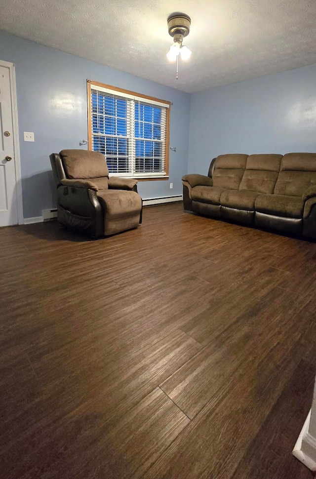 living room featuring ceiling fan, dark hardwood / wood-style flooring, a baseboard radiator, and a textured ceiling