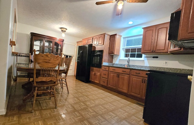 kitchen with black appliances, ceiling fan, dark stone countertops, a textured ceiling, and light parquet flooring