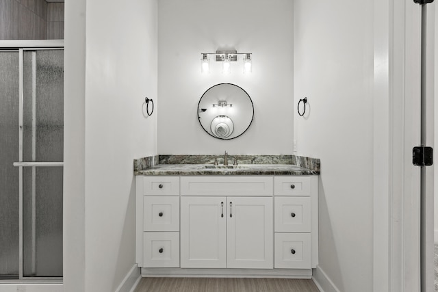 bathroom featuring vanity, a shower with shower door, and hardwood / wood-style floors