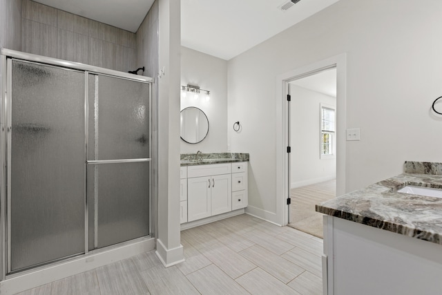 bathroom featuring vanity and a shower with door