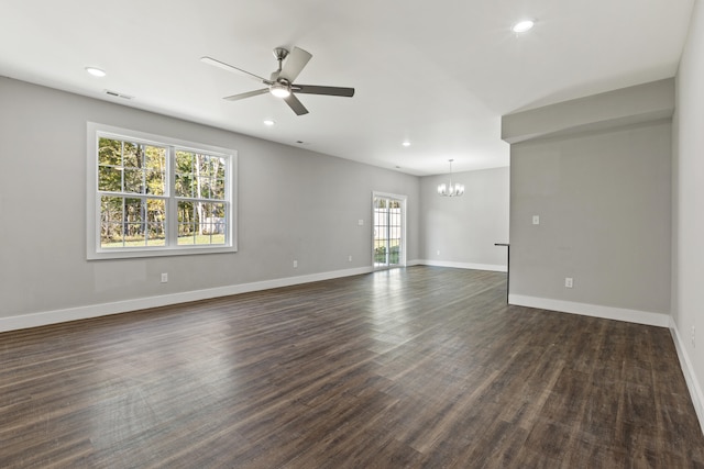 spare room featuring a wealth of natural light, dark hardwood / wood-style floors, and ceiling fan with notable chandelier