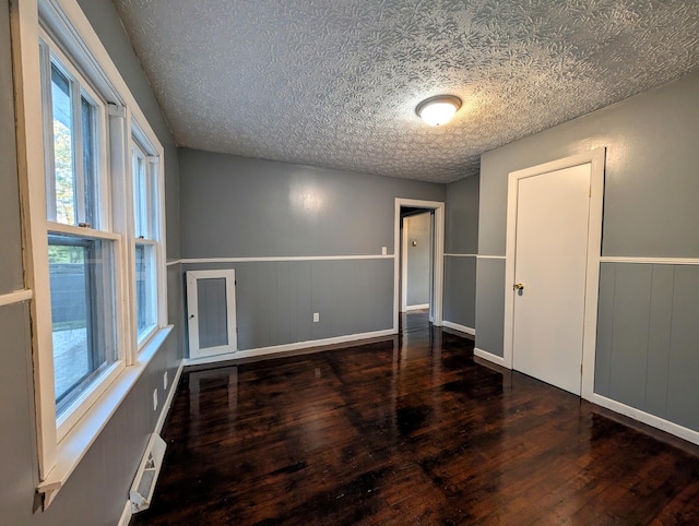 spare room with dark wood-type flooring and a textured ceiling