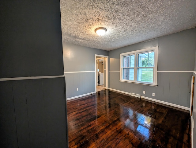 unfurnished room with a textured ceiling and hardwood / wood-style floors