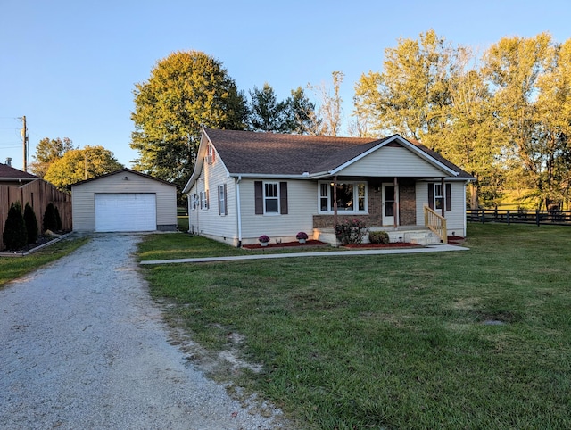 view of front of house featuring an outdoor structure, a front yard, covered porch, and a garage