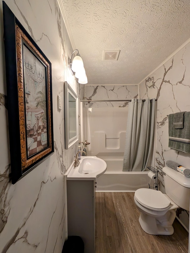 full bathroom with vanity, toilet, a textured ceiling, and shower / bath combo