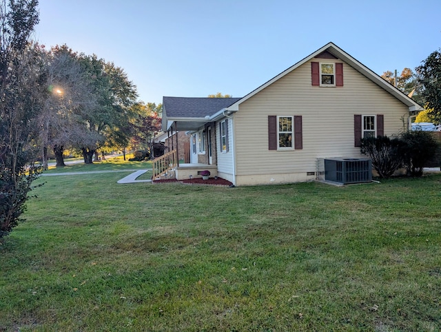 view of home's exterior with central AC and a lawn