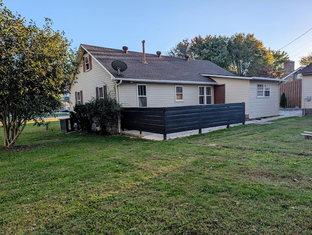 rear view of property featuring a lawn