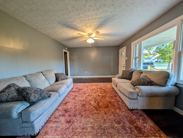 living room with ceiling fan, a textured ceiling, and wood-type flooring