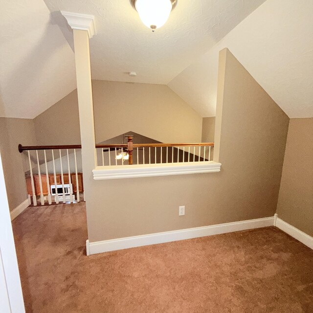 additional living space with carpet flooring, a textured ceiling, and vaulted ceiling