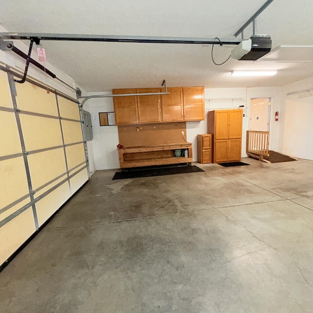 garage with electric panel and a garage door opener