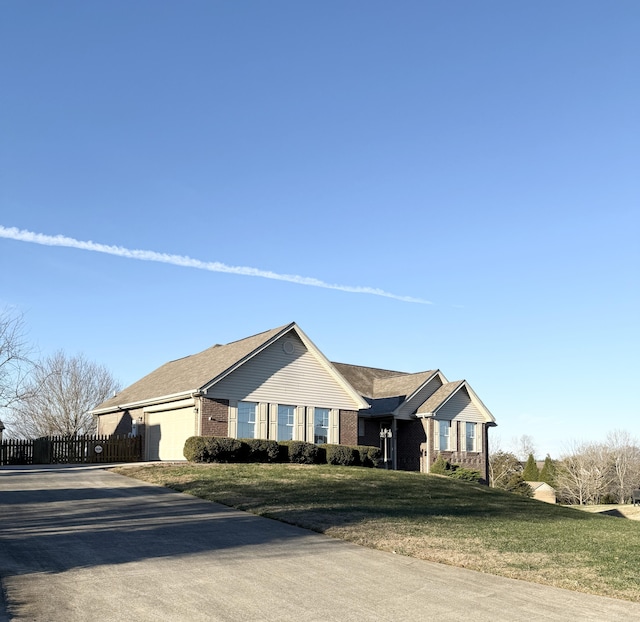 ranch-style house featuring a garage and a front lawn