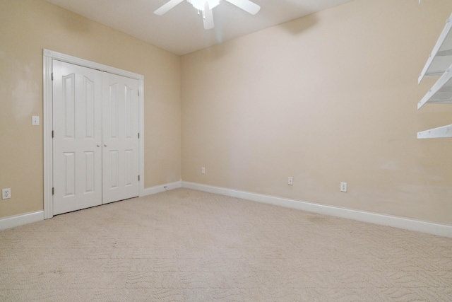 unfurnished bedroom featuring ceiling fan, light carpet, and a closet