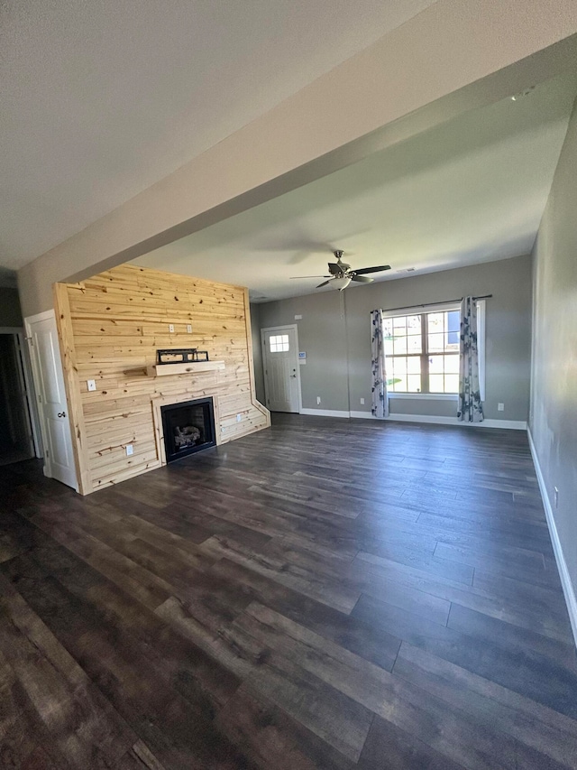 unfurnished living room with dark wood-type flooring and ceiling fan