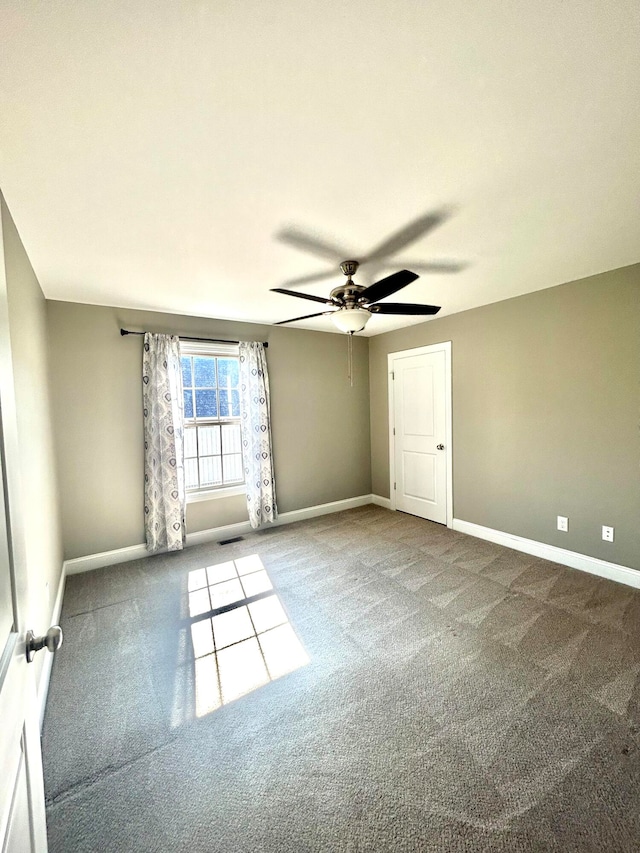 empty room with ceiling fan and carpet floors