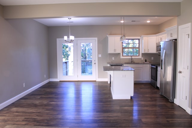 kitchen featuring appliances with stainless steel finishes, a center island, dark wood-type flooring, and pendant lighting