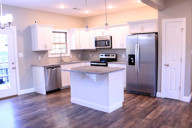 kitchen with sink, pendant lighting, white cabinetry, appliances with stainless steel finishes, and dark hardwood / wood-style flooring