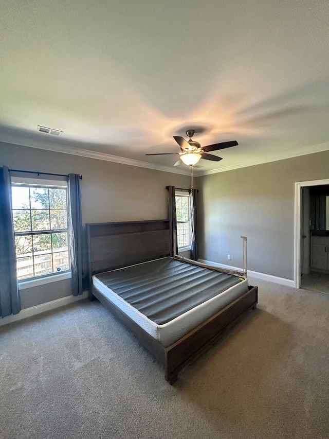 unfurnished bedroom with ornamental molding, carpet, multiple windows, and ceiling fan