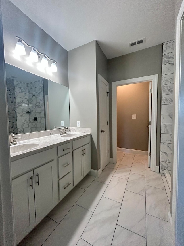 bathroom featuring vanity, a textured ceiling, and tiled shower