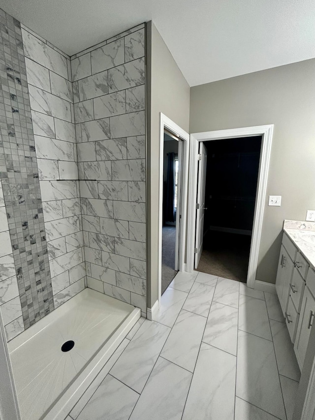 bathroom with vanity, a textured ceiling, and a tile shower