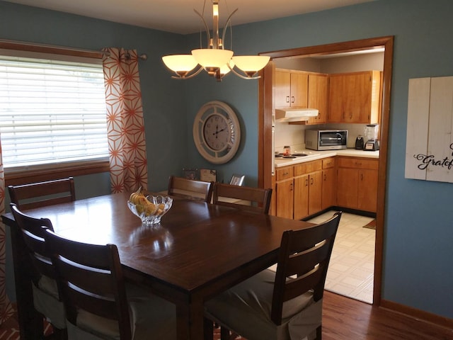 dining space with a notable chandelier and light wood-type flooring