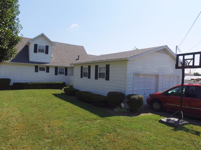 rear view of house featuring a yard and a garage