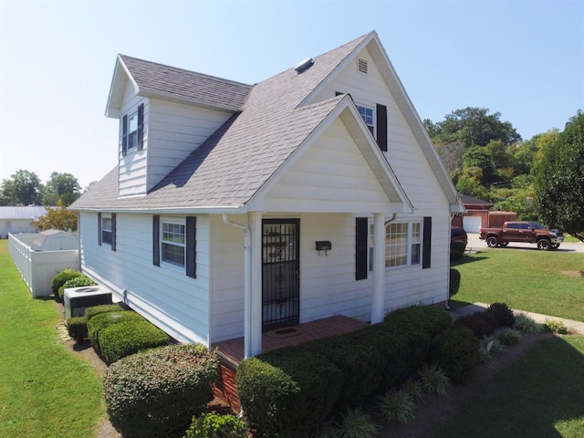 view of front of property featuring a front yard and cooling unit