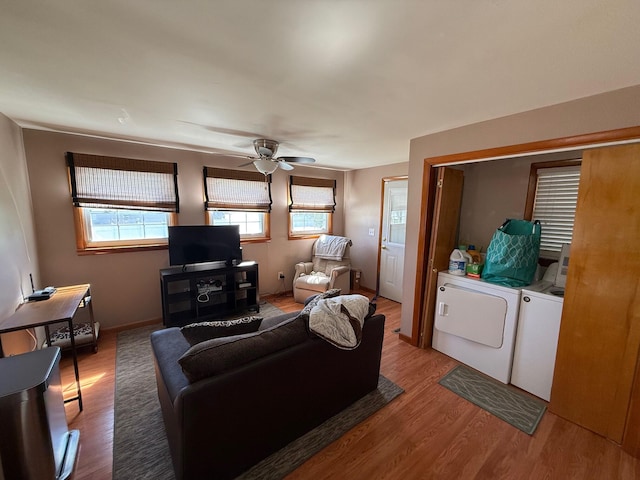 living room with independent washer and dryer, wood-type flooring, and ceiling fan