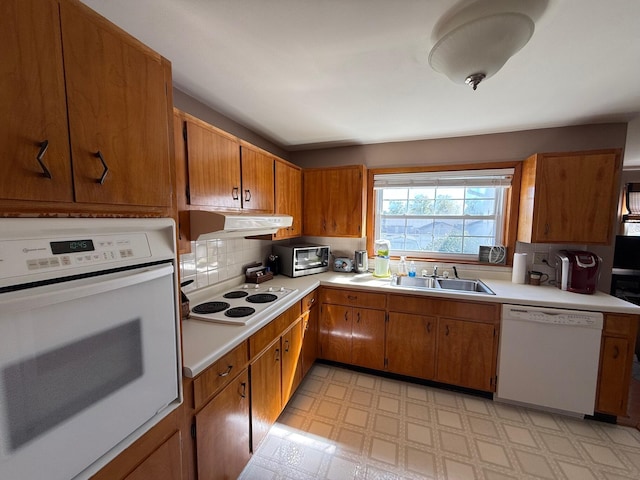 kitchen with sink, decorative backsplash, and white appliances