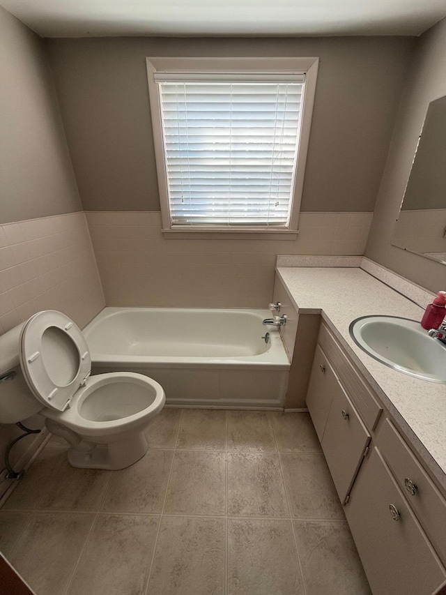 bathroom with toilet, vanity, tile patterned floors, and a washtub