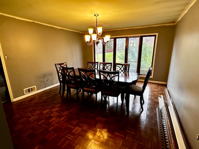 dining room featuring dark parquet flooring, ornamental molding, and an inviting chandelier