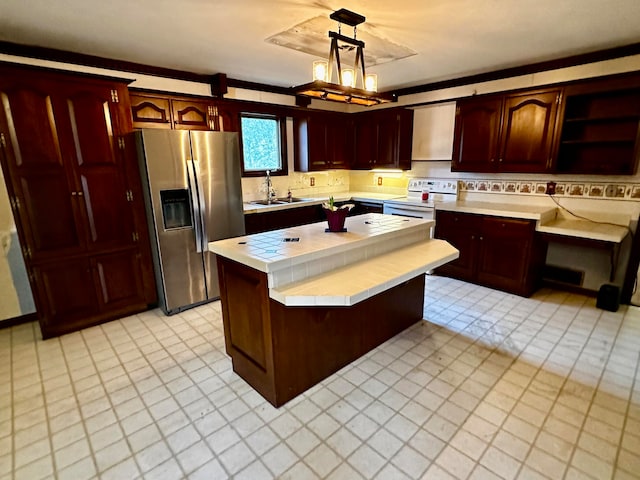 kitchen with stainless steel refrigerator with ice dispenser, ventilation hood, sink, decorative light fixtures, and white electric range