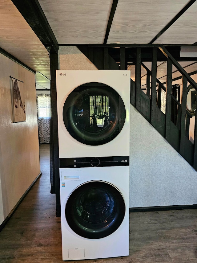 clothes washing area with stacked washer and dryer and dark hardwood / wood-style floors