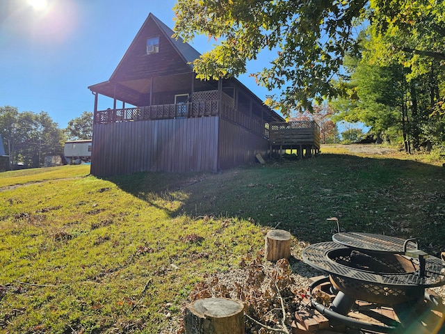 view of yard featuring an outdoor fire pit and a deck