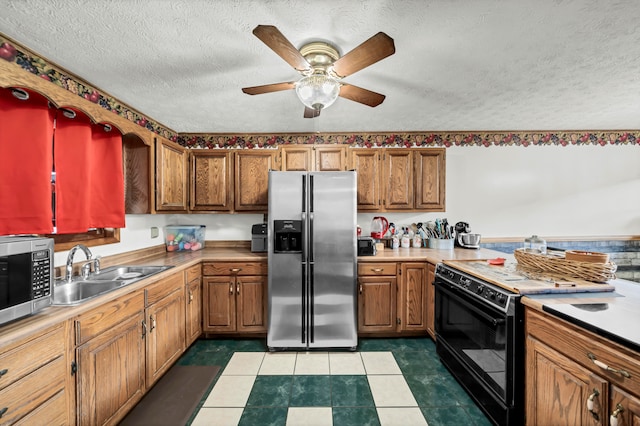 kitchen featuring appliances with stainless steel finishes, a textured ceiling, sink, and ceiling fan