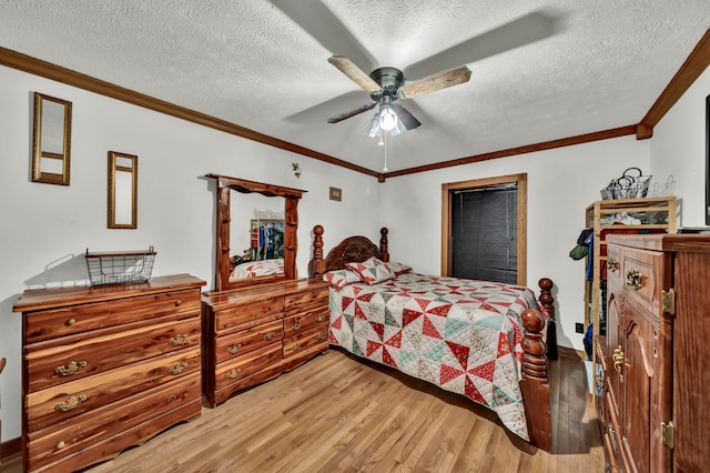 bedroom featuring ceiling fan, a textured ceiling, ornamental molding, and hardwood / wood-style floors