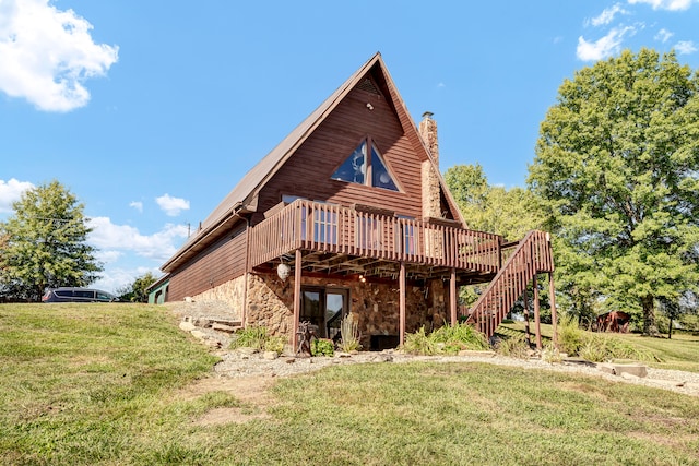 rear view of house featuring a wooden deck and a lawn