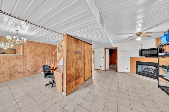 interior space with ceiling fan, wood walls, beamed ceiling, and light tile patterned floors