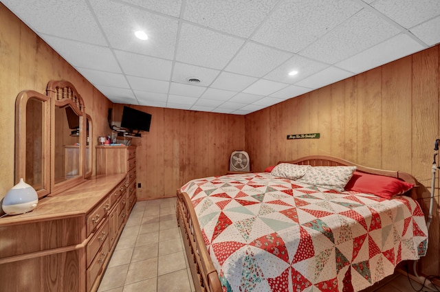 tiled bedroom with a paneled ceiling and wood walls