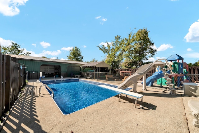 view of swimming pool featuring a water slide and a patio