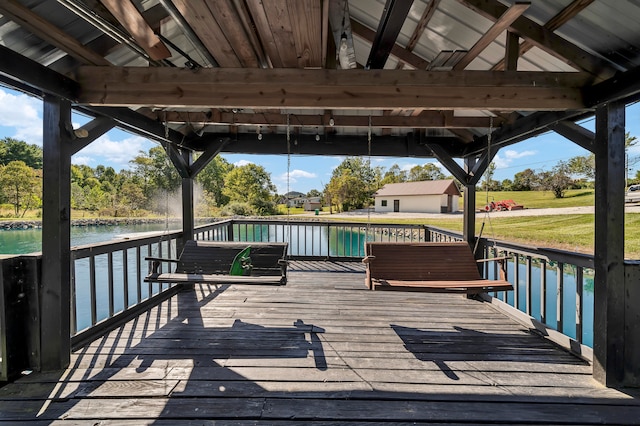 deck with a water view, a gazebo, and a yard