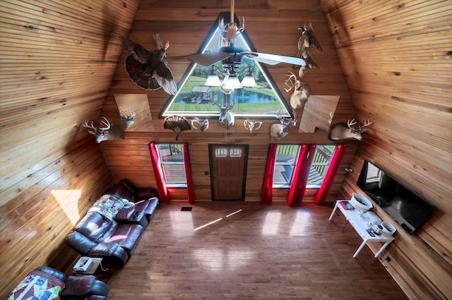 foyer featuring wooden walls, vaulted ceiling, and dark wood-type flooring